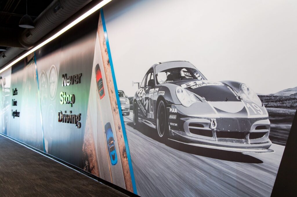 Hagerty storytelling mural: a racing Porsche and "Never Stop Driving"