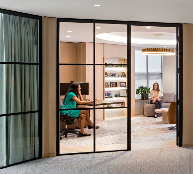 A glass-walled meeting room beside a timber reception desk