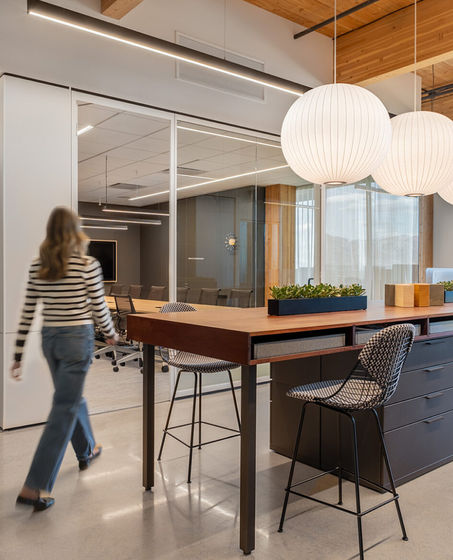 A glass-walled meeting room and shared worktable in a COR showroom